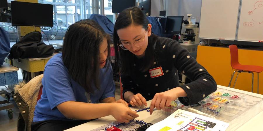 A female graduate student working with STEM Starters teaches a girl about electronics at a workshop in the Education Lab.