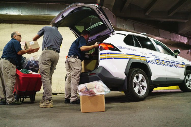 Members of Columbia University’s Public Safety department loading backpacks en route to the back-to-school drive. Photo Credit: Henry Danner