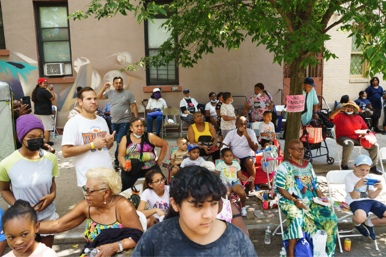 Attendees focused on the live entertainment at the back-to-school event in West Harlem. Photo Credit: Henry Danner