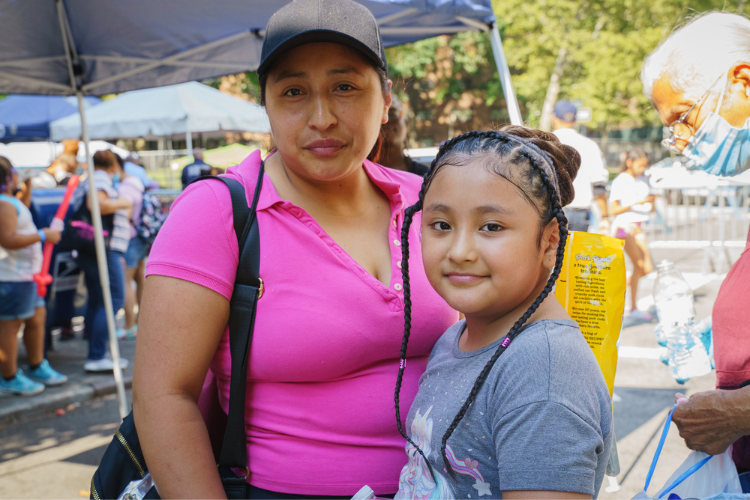Mia Castillo and her mother Sandra strike a pose after Mia received a complimentary hairstyle at the back-to-school event in West Harlem. Photo Credit: Henry Danner