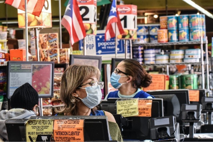 Grocery store cashiers in protective masks, in New York City, on April 2, 2020. © Stephanie Keith/Getty