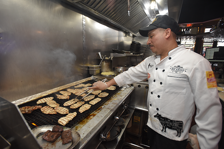 Chef at Ricardo Steakhouse prepares meals for Columbia University Friends and Neighbors Meal to Go program. Image by Susan Farley. Chef cooking at Ricardo Steakhouse.
