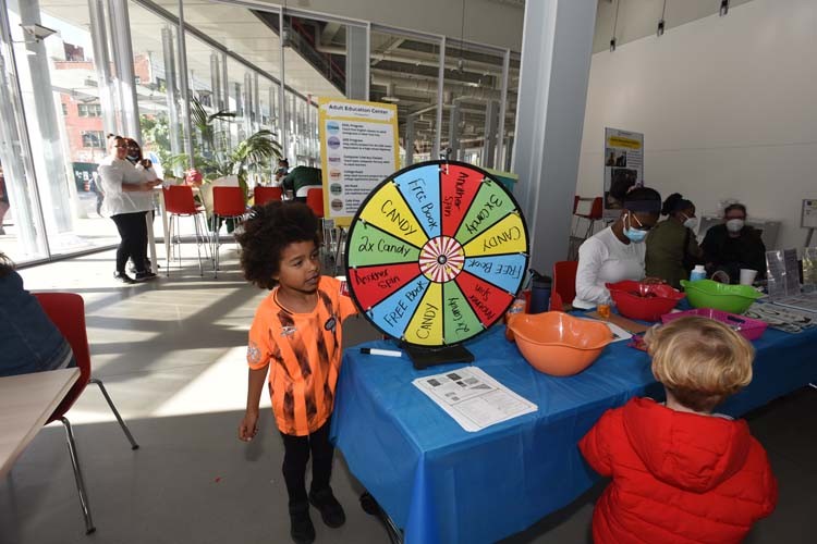 An attendee spins the wheel at the Community Impact table