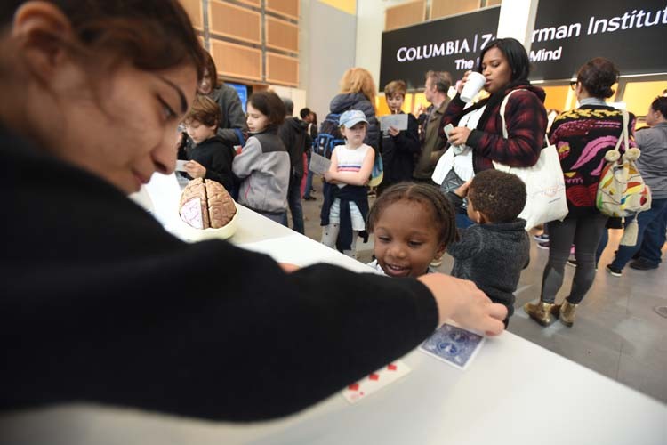 A Saturday Science staffer participates in a learning activity with a young child. 