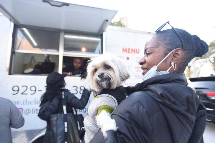 An attendee and her pup wait outside of the Little Hot Dog Wagon.