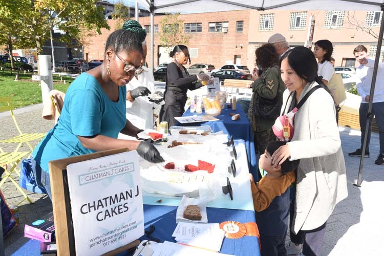 Chatman J Cakes' booth offered delicious samples next to Kamuni Creek Beverages. Photo by Susan Farley. Chatman Cakes representative hands out samples.