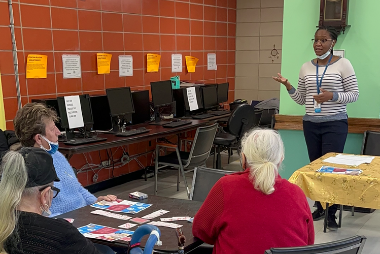 Photo by Jaunia Coombs-Clark. A woman teaches two women in a room.