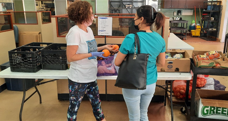 Two workers hold fruit