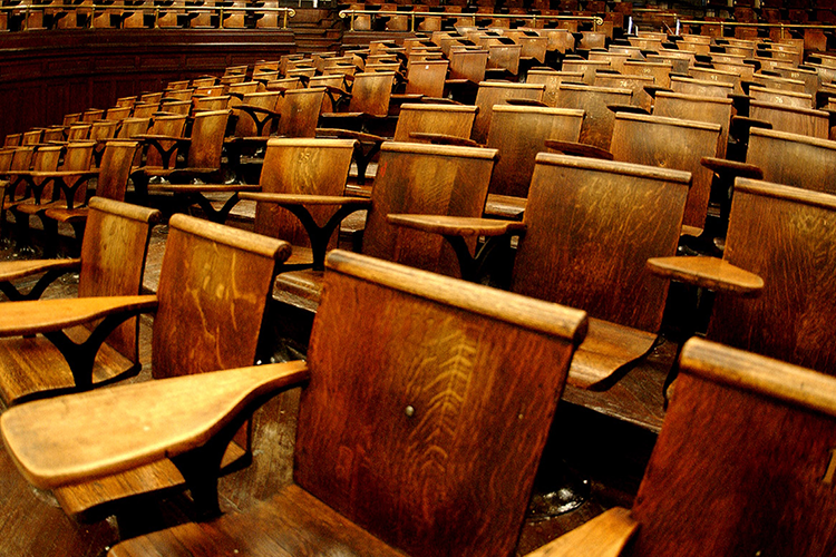 A lecture room in Columbia's Havermeyer Hall. Empty wooden desks in Columbia's Havermeyer Hall.