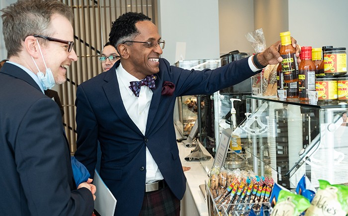 Assembly Member Al Taylor and Nathan Robb, Assistant Vice President for Government Relations in Columbia's Office of Government and Community Affairs, inspect Virginia Higginbotham's Mama's One Sauce, one of the local vendors on sale in Geffen Hall's ground floor cafe, open to the community. Photo by Diane Bondareff. 