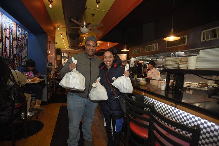 Columbia neighbors smiling and grabbing food. 