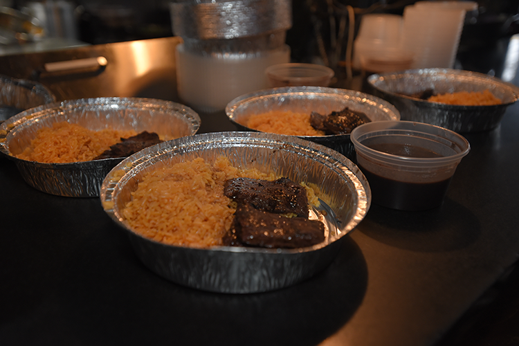 Delicious meals freshly prepared at Ricardo Steakhouse that were distributed to neighbors and community members. Image by Susan Farley. Platters by Ricardo Steakhouse.