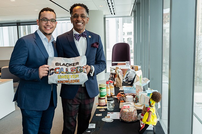 City Council Member Shaun Abreu and Assembly Member Al Taylor display a sweatshirt from a Harlem Local Vendor Program participant. 