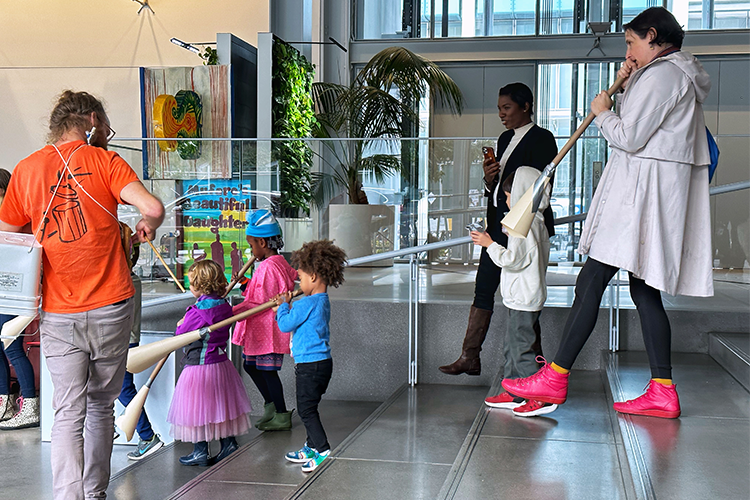 A parade of children with instruments made out of cardboard. 