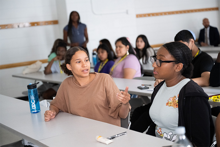 Two students speak to one another in the Double Discovery Classroom.