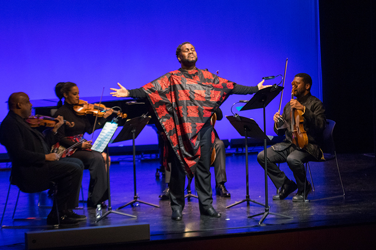 Man performing at the front of an orchestra. 