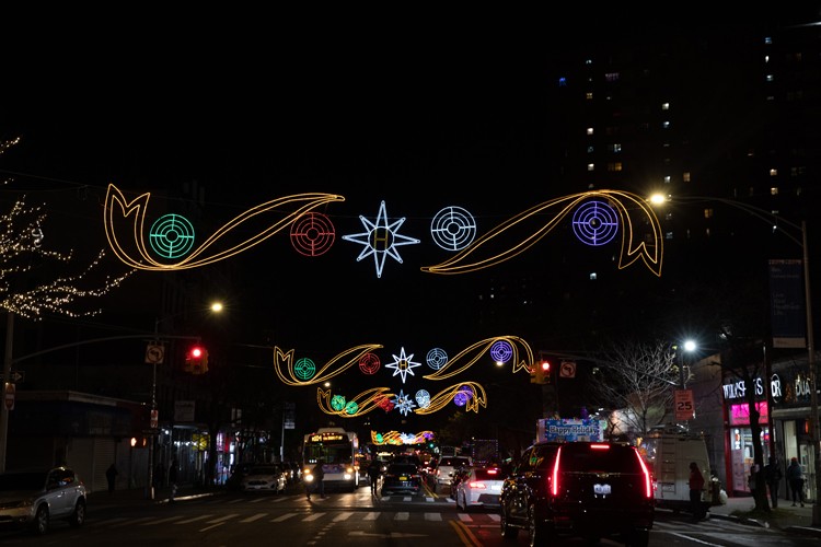 125th Street in Harlem with festive holiday lighting above the road. 