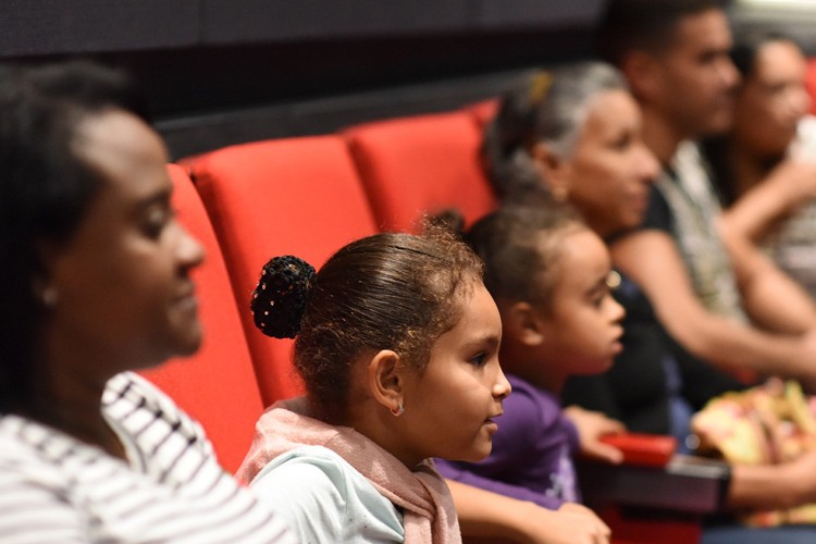 Kids in a theatre watching a film.