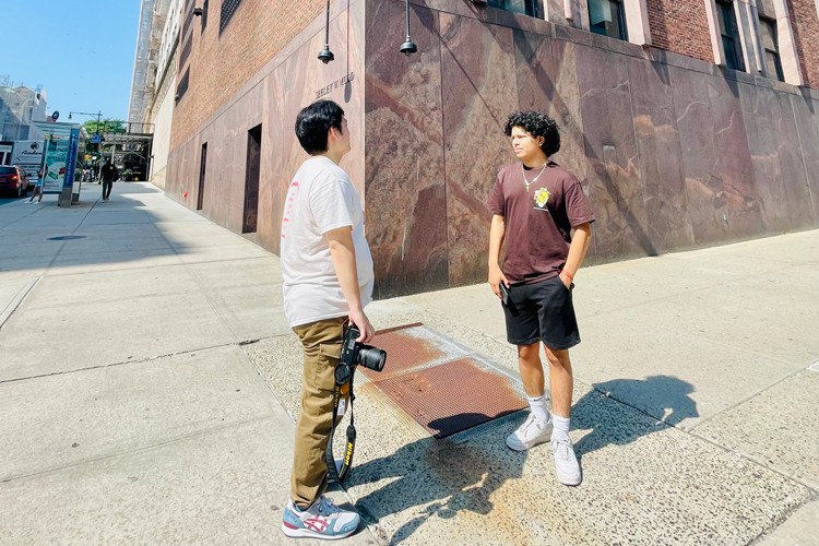 Ezra Ju (left) and Joel Lazcano (right) in Manhattanville during a photography outing. Photo credit: The Trust Collaboratory Two students of the My Streetscape Summer School stand in conversation during a photography session.