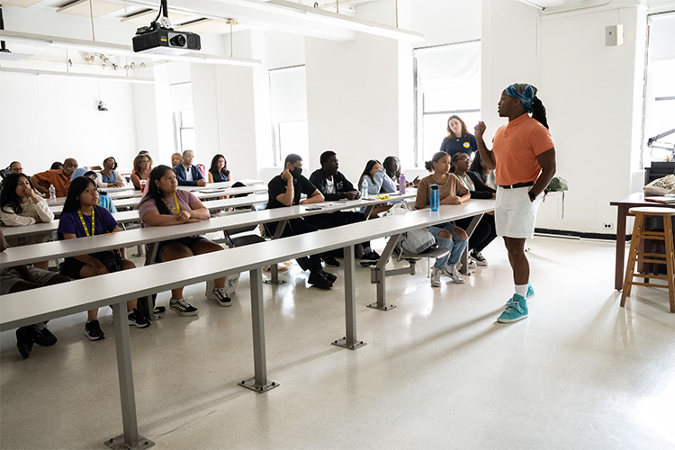Sociology Instructor and Columbia Ph.D. student Jay Brown addresses a class of Double Discovery Center students, local elected officials, and Columbia President Minouche Shafik. Photo by Diane Bondareff/Columbia University. Sociology Instructor Jay Brown addresses a class of Double Discovery Center students, local elected officials, and Columbia President Minouche Shafik.