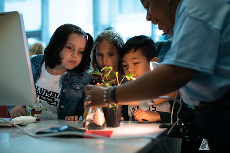 Students look at a plant. 