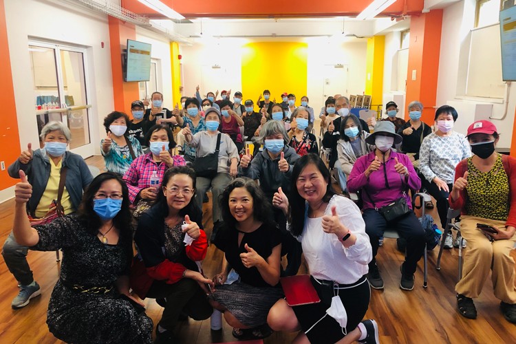 Photo credit: Upper Manhattan Asian American Alliance. Seniors smiling at UMAAA meeting.