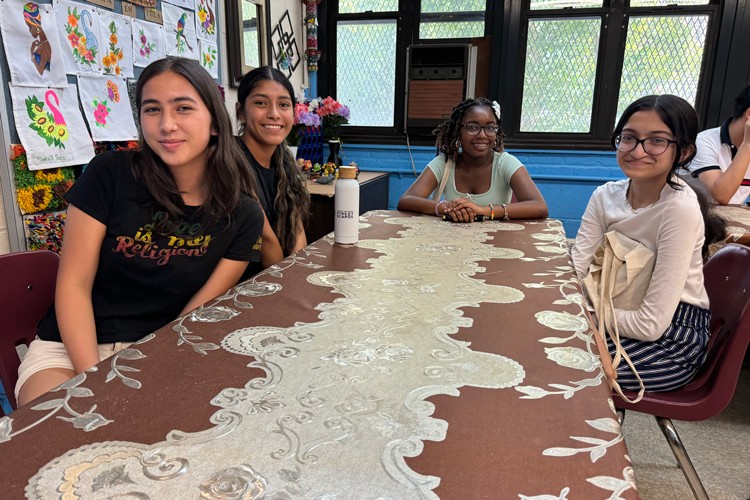 Left to right: Rising seniors Allegra Advincula (LaGuardia High School of Music), Keshley Toribio (Park East High School), Gynnel Jeffrey (Urban Assembly Gateway School for Technology), and Ishrat Sajjad (Manhattan Center for Science and Math) with the Center for Smart Streetscapes "My Streetscape Summer Research Institute" join Harlem residents at the Jackie Robinson Senior Center. Photo credit: Center for Smart Streetscapes Group of students sitting at a table during a visit to a senior center.