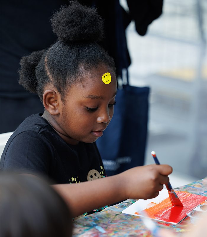 A young Manhattanville Community Day visitor works on an art project. Photo by Sirin Samman. A little girl paints at community day.