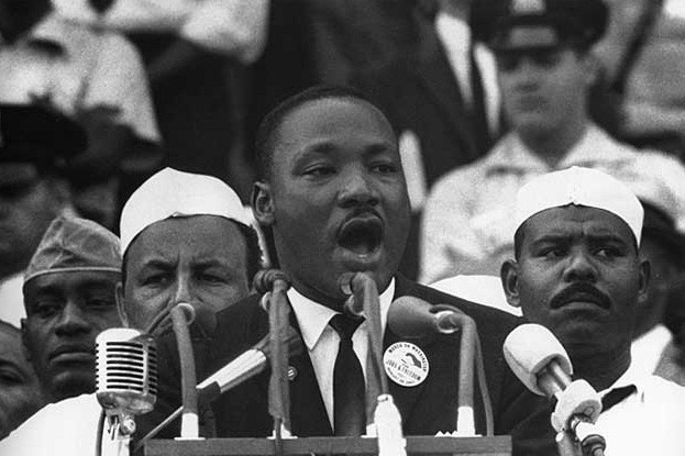 Martin Luther King Jr. delivering his famous "I Have a Dream" speech in front of a podium. 