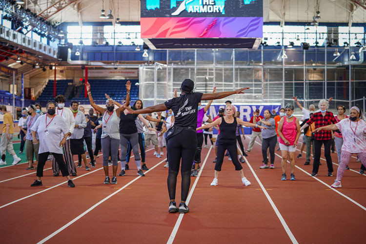 Instructor leading seniors through a dance class in The Armory. 