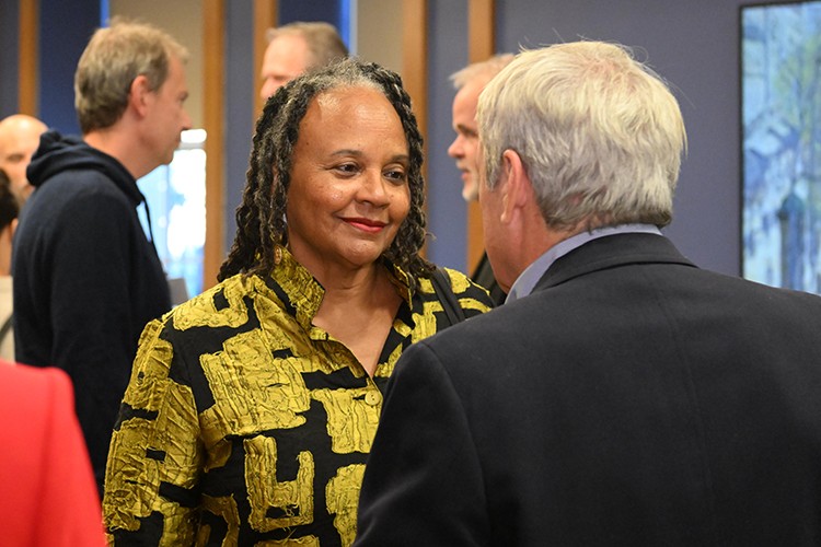 Valerie Rochon speaking with George Calderaro. A woman and a man stand next to each other talking.