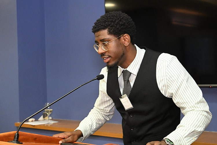 Joseph Malik Suba Turner, a member of the 12th cohort, shares about his project. A man talking to a group of people.