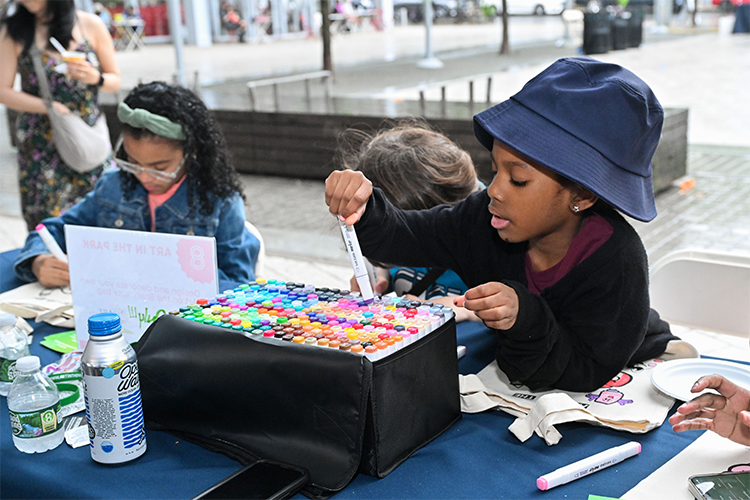 At Wallach Art Gallery's tables, young attendees brought drawings to life by making thaumatropes—one of the earliest animation devices. Photo by Diane Bondareff. Kids play with art materials