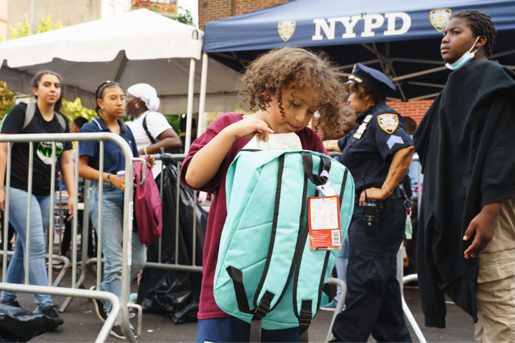 Attendees at the back-to-school event receive backpacks filled with school supplies. Photo Credit: Henry Danner