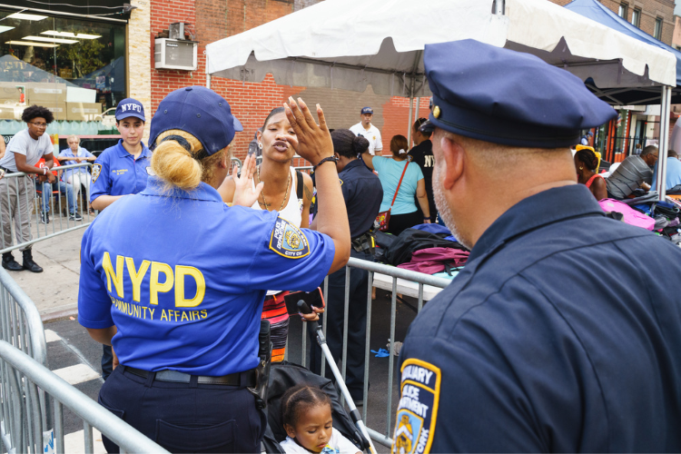 Detective Ureña greets a parent after she was given a backpack for her child. Photo Credit: Henry Danner