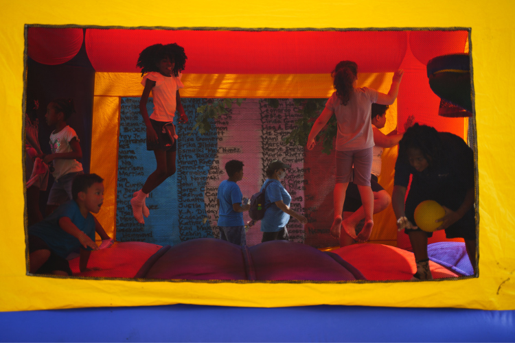Children play in a bouncy house during the annual back-to-school event in West Harlem. The event is hosted every year by the 26th Precinct, Community Board 9, and the West Harlem Development Corporation, and is made possible by donations from a variety of partners including Columbia University. Photo Credit: Henry Danner