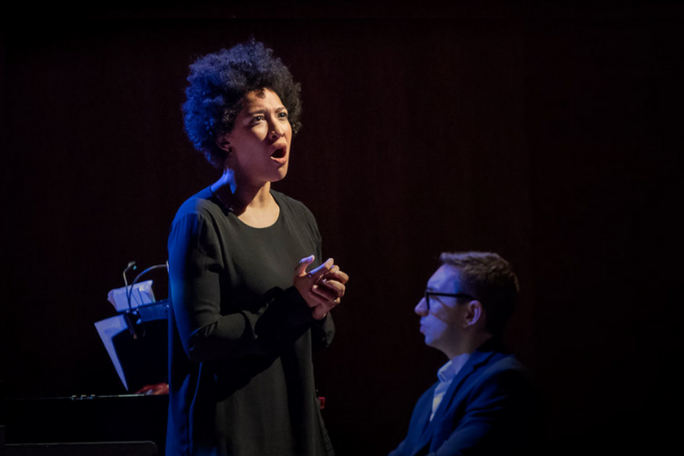 A woman in a black dress singing