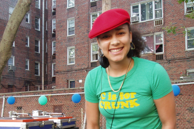 Amanda Seales in green t-shirt and red cap