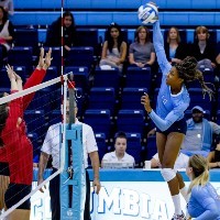 A woman spiking a volleyball.