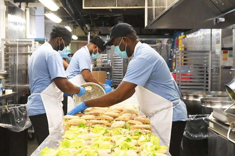 Columbia dining employees create meals in kitchen.
