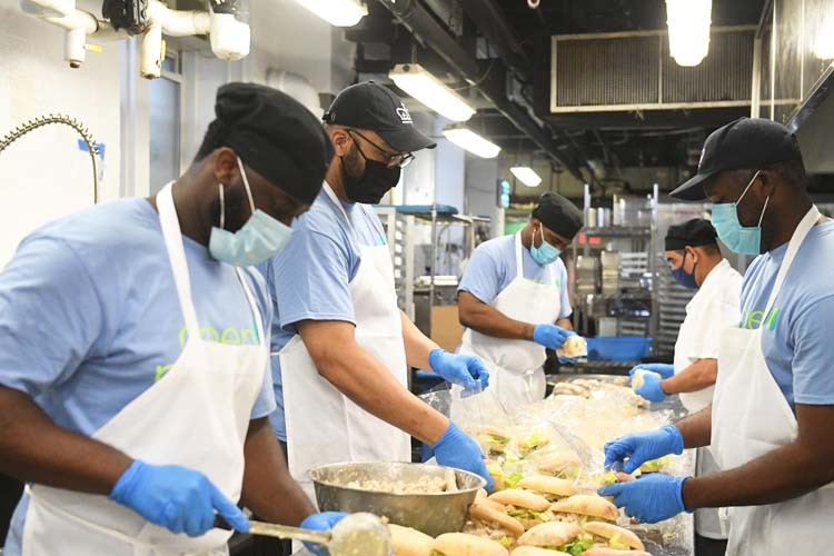 Columbia dining employees create meals in kitchen.