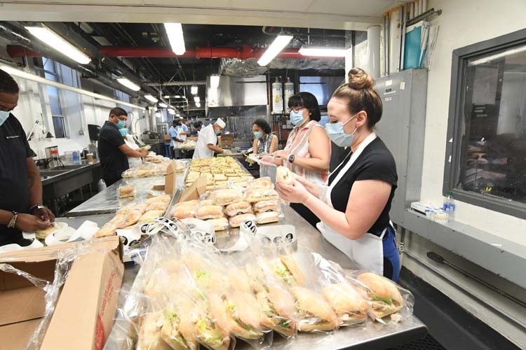 Columbia dining employees create meals in kitchen.