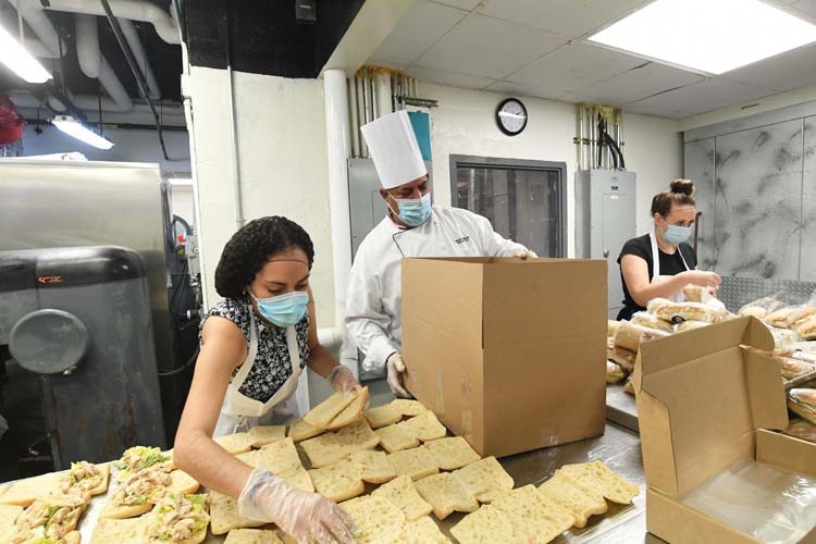 Columbia dining employees create meals in kitchen.