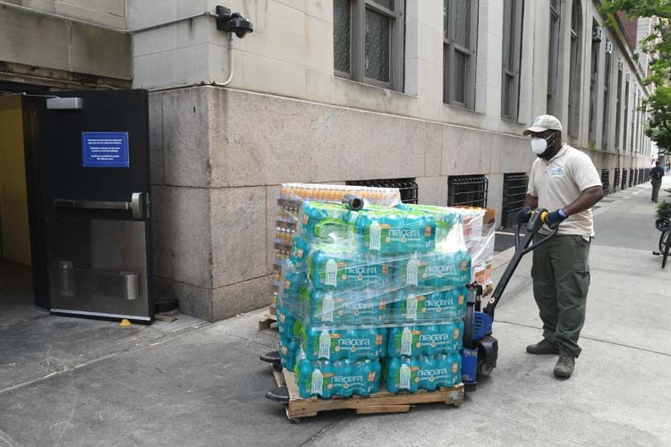 Columbia dining employees transport meals on dolly.