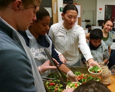 Volunteers serving salad to homeless