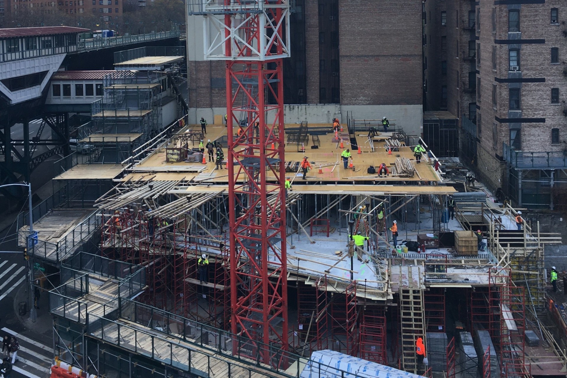 An aerial view of the 600 W. 125th Street construction site from the Forum, with a large red crane on the site.