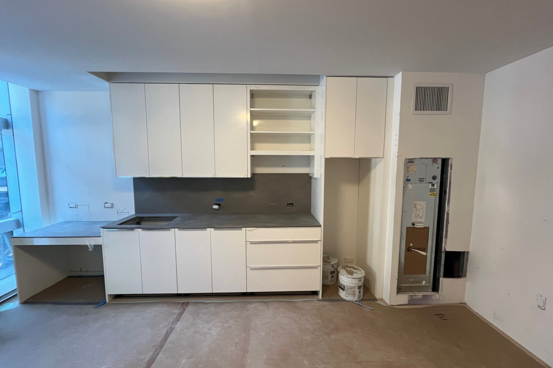 A completed kitchen inside an apartment unit in 600 W. 125th Street that has white finishes.