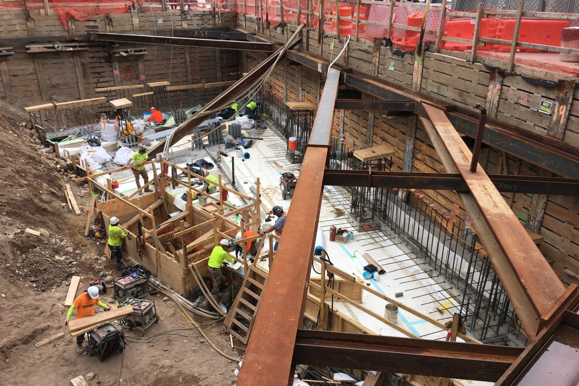 A view of the 600 W. 125th Street construction site with steel beams running across a dirt pit. 