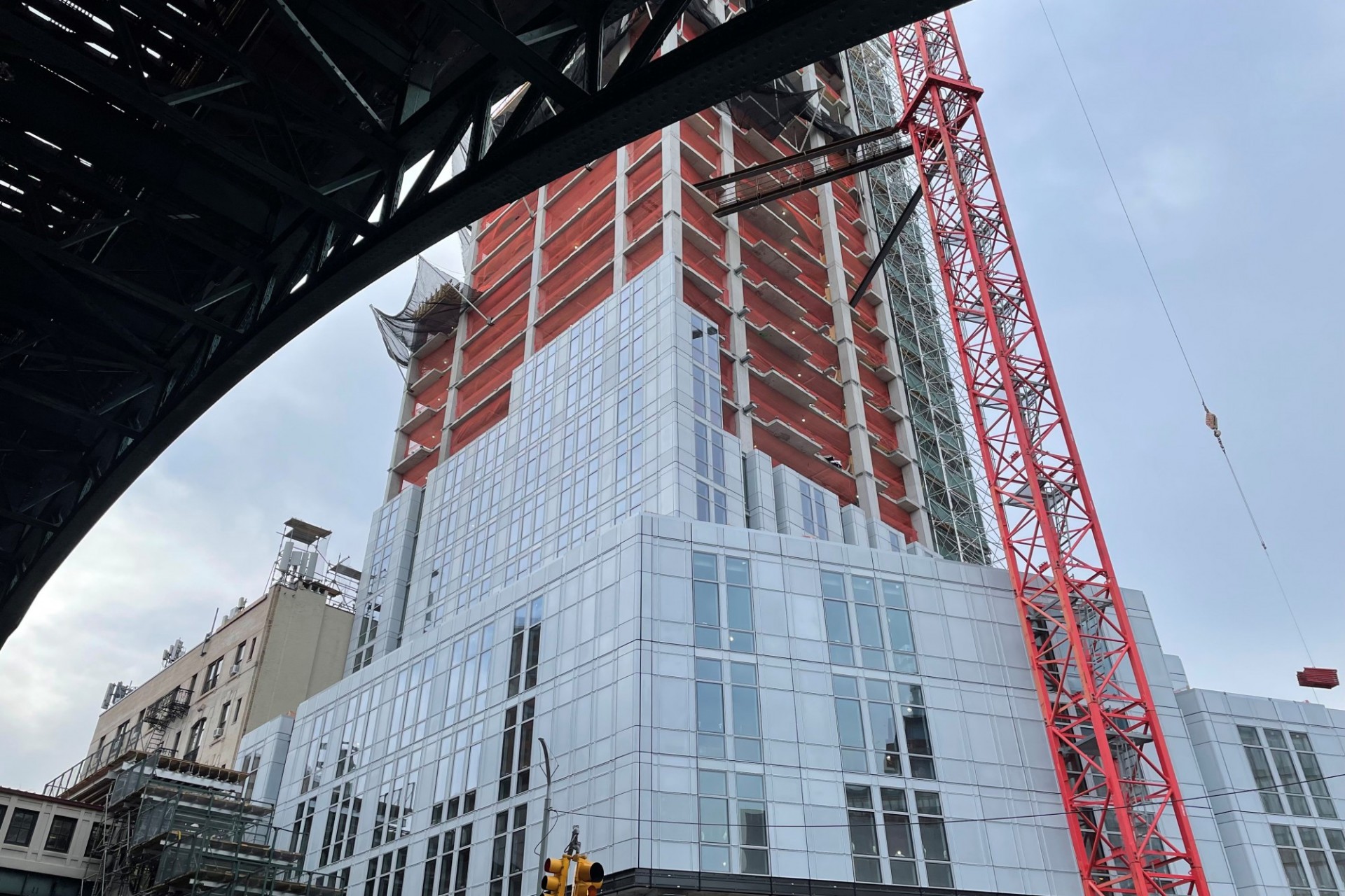 A view of the 600 W. 125th Street construction site near the street level, which has facade panels installed around it. 