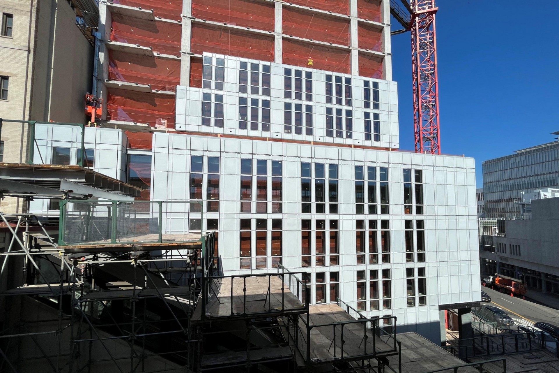 A view of the 600 W. 125th Street construction site near the street level, which has facade panels installed around it. 